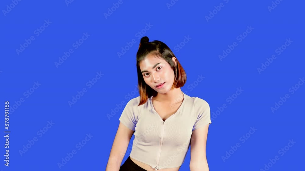 Attractive asian student with short fair hair. Smiling young woman thinking and posing on blue wall background. Attractive asian student with short fair hair. Smiling young woman thinking and posing on blue wall background.