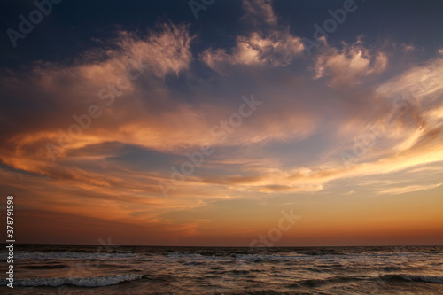 Beautiful sunset in sky, sandy beach on sea coast