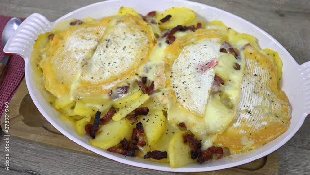 plat de tartiflette au reblochon sur uine table en bois plat de tartiflette au reblochon sur uine table en bois