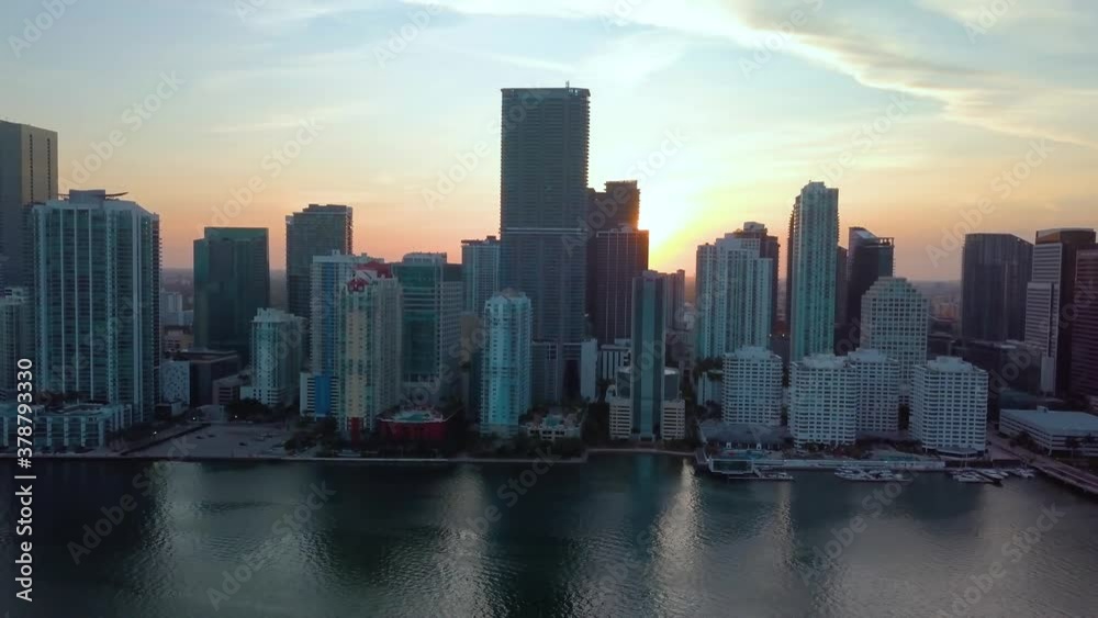 Aerial view of the sunrise, behind high rise buildings, in the Brickell district, on a sunny morning, in Miami, Florida, USA - tracking, drone shot Aerial view of the sunrise, behind high rise buildings, in the Brickell district, on a sunny morning, in Miami, Florida, USA - tracking, drone shot