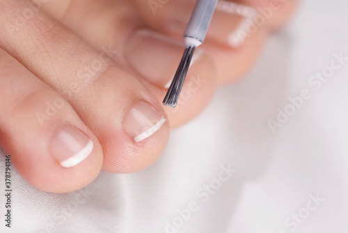 Close-up of a woman applying nail polish on her toes