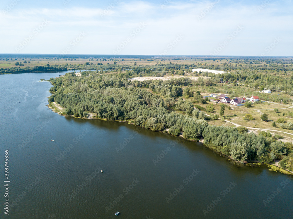 Green banks of a country river. Aerial drone view, sunny summer day.