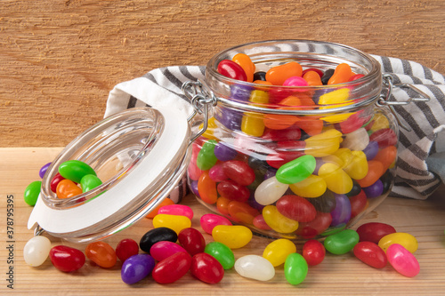 a preserving jar of colorful jelly beans on a wooden shelf