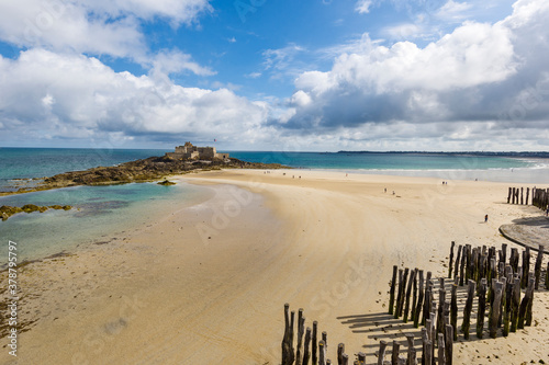 fort national and wooden poles on the beach at low tide in Saint Malo, Brittany, France