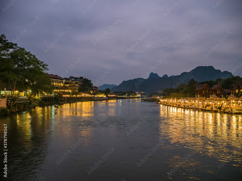 Beautiful view of nam song river with riverside restaurant and the mountain in the night at Vangvieng city Lao.Vangvieng City The famous holiday destination town in Lao.