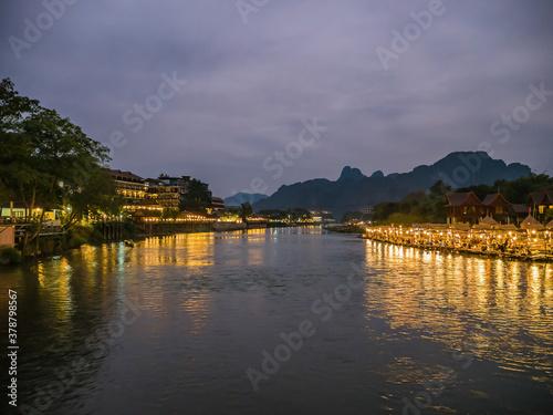 Beautiful view of nam song river with riverside restaurant and the mountain in the night at Vangvieng city Lao.Vangvieng City The famous holiday destination town in Lao.