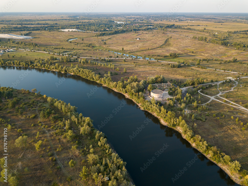 Aerial drone view. The bend of a wide river among green meadows. Sunny summer day. Aerial drone view. The bend of a wide river among green meadows. Sunny summer day.