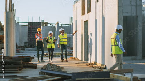 Diverse Team of Specialists Taking a Walk Through Construction Site. Real Estate Building Project with Senior Civil Engineer, Architect, General Worker Discussing Planning and Development Details.