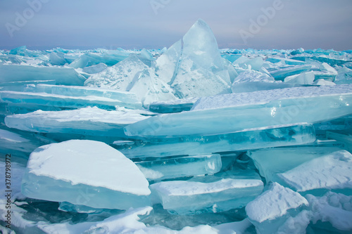 Lake Baikal in winter. Beautiful view of frozen water. Textured blocks of clear blue ice. Mountains and icy texture landscapes. Observation of wild world. Adventure on lake Baikal  Russia