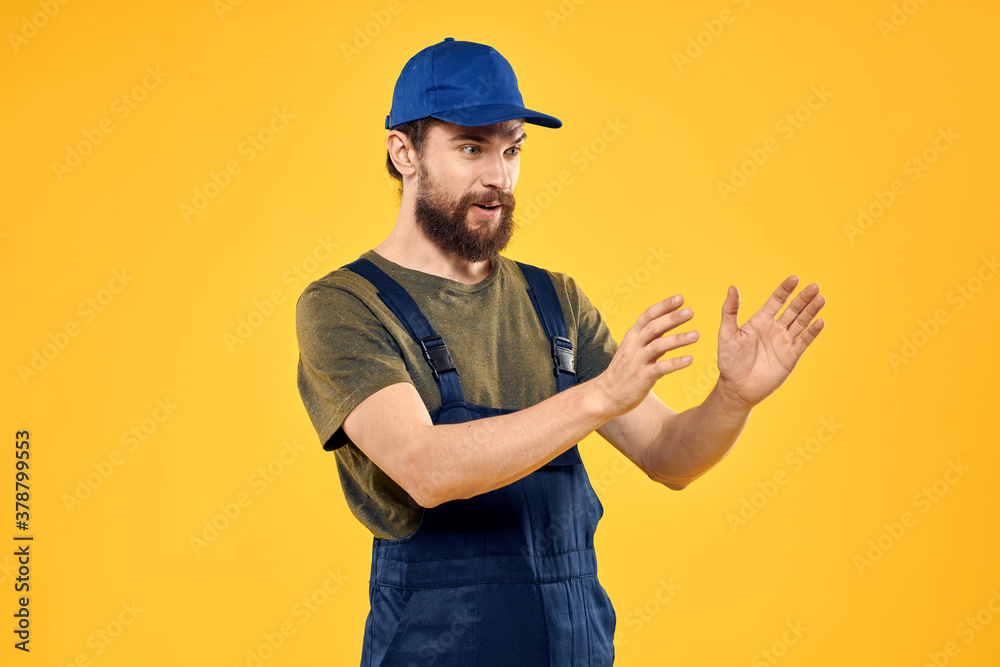 Worker man in uniform worker service yellow background emotion