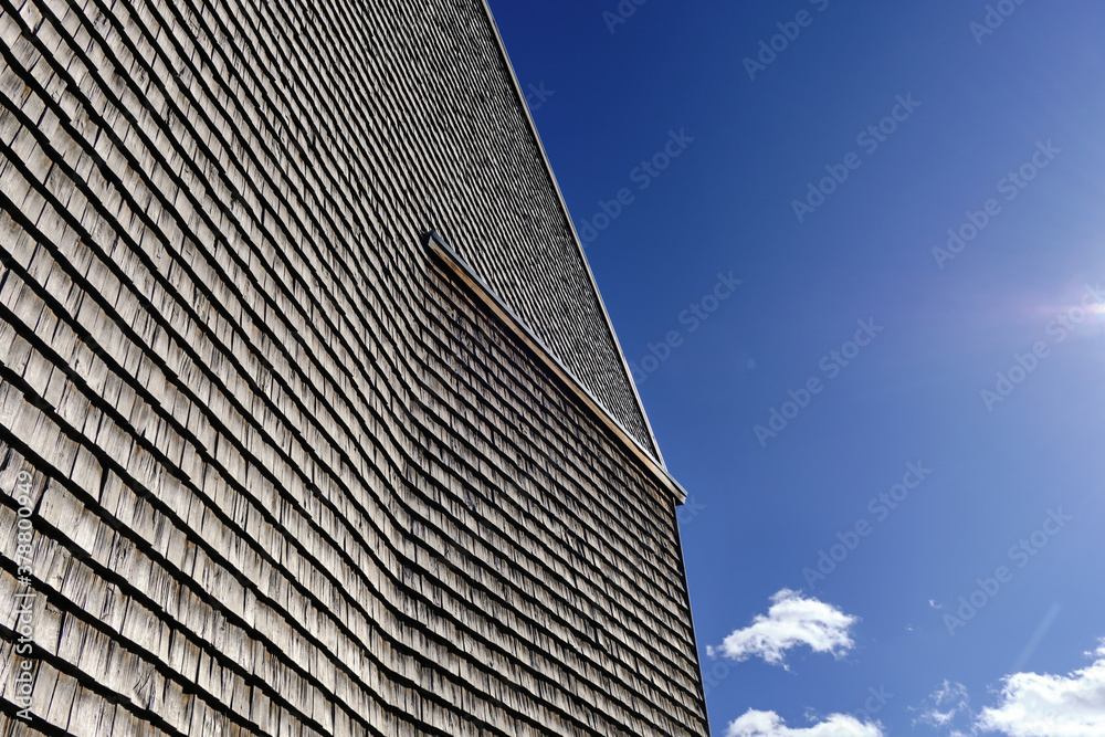 The facade of a modern wooden building on the blue sky background.