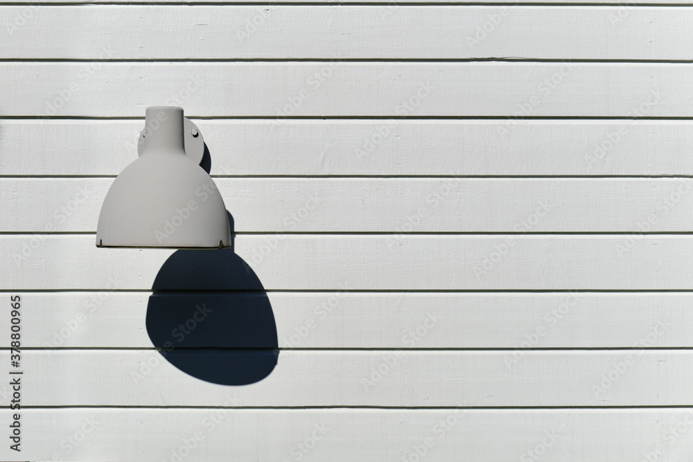The outdoor lamp on the wooden wall.