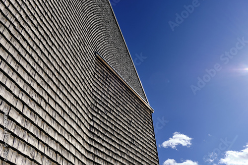Obraz na płótnie The facade of a modern wooden building on the blue sky background. w salonie