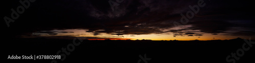 Large natural panorama of salar de Uyuni salt marsh in Bolivia at sunset. Amazing colorful view of setting sun late in evening in good weather. Concept of travel. Copyright space for the site