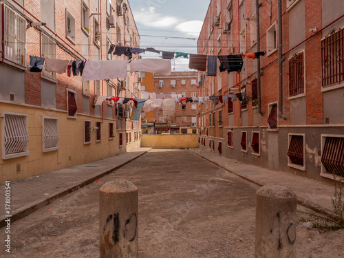 POOR NEIGHBORHOOD STREET WITH LAYING CLOTHES AND GARBAGE