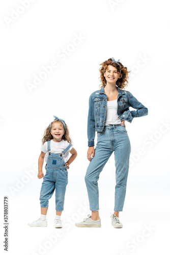mother and daughter in denim outfits posing isolated on white