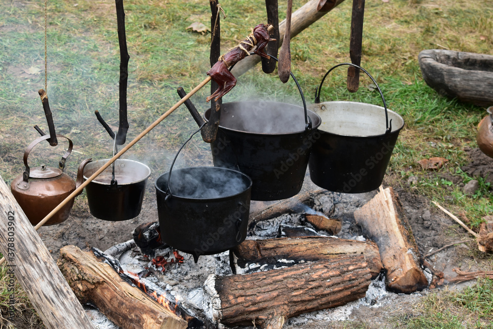 Kettles cooking over a campfire at an autumn festival reenactment Kettles cooking over a campfire at an autumn festival reenactment