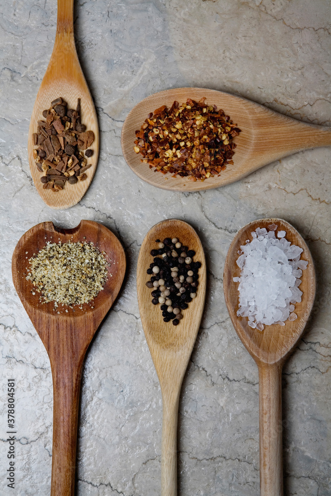 High angle view of spices in wooden spoons High angle view of spices in wooden spoons