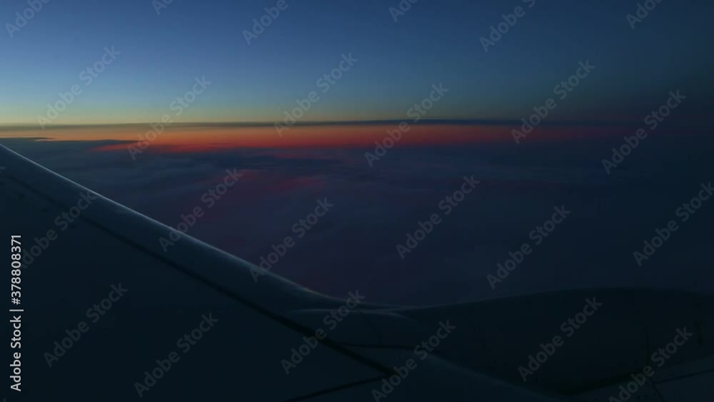 aerial view from airplane window across steel wing silhouette at dark sunset sky aerial view from airplane window across steel wing silhouette at dark sunset sky