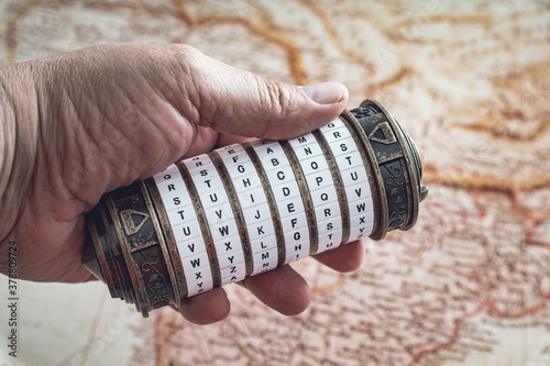 Hand holding a cryptex with a map in the background photo