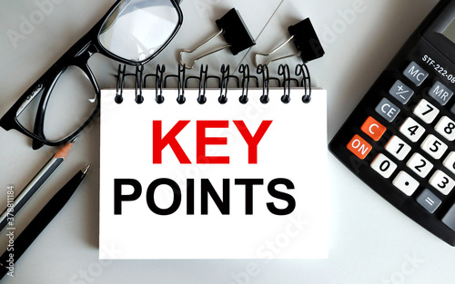 KEY POINS. TEXT ON WHITE sheet of paper on gray background near paper clips glasses calculatorBusiness, technology, internet concept. Stock Photo photo