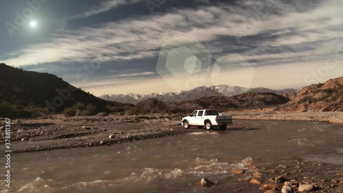 Pick Up Truck crossing Muddy River at Sunset.