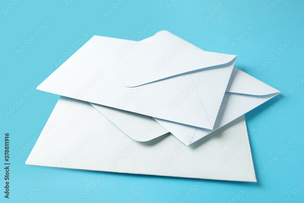 White paper envelopes on light blue background, closeup White paper envelopes on light blue background, closeup