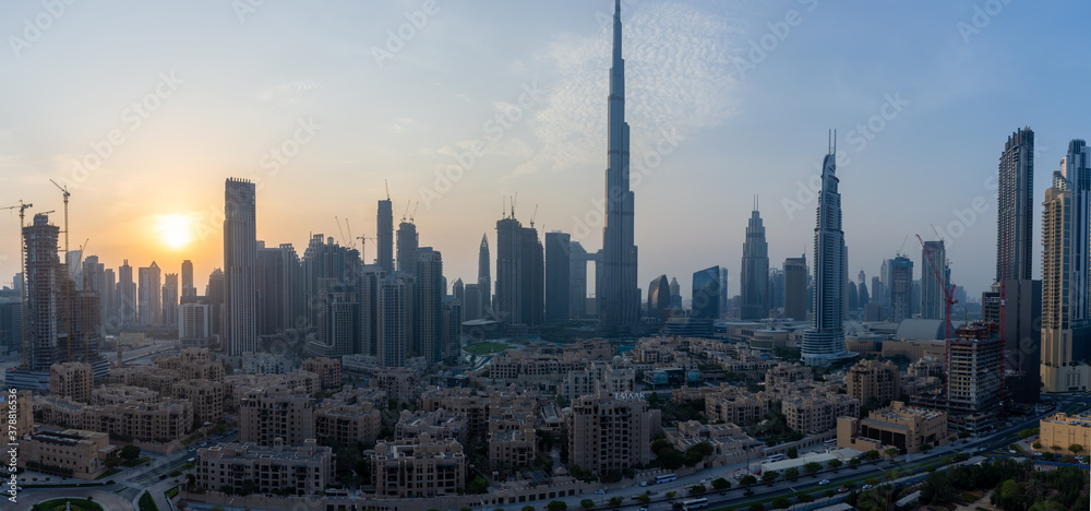 Iconic panorama at sunset of Burj Khalifa and Dubai Skyline as sun sets with and other skyscrapers in the Middle East with blue sky