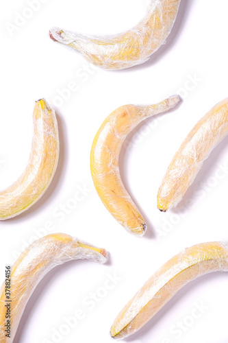 Banana fruits wrapped in stretch wrap plastic isolated background, minimalistic creative layout, ecology and environment concept