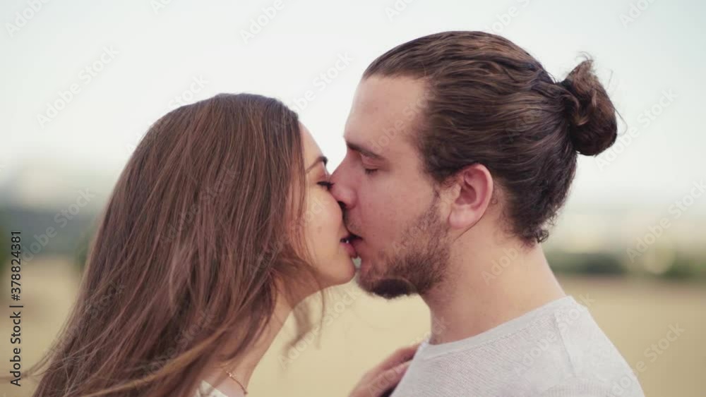 A Couple Deeply In Love Sharing A Romantic Kiss - Portrait Of A Young Couple Passionately Kissing In Nature. - close up shot A Couple Deeply In Love Sharing A Romantic Kiss - Portrait Of A Young Couple Passionately Kissing In Nature. - close up shot