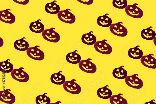 Creative beautiful fashion seamless pattern of laughing funny pumpkin silhouette and its shadow on yellow background.The Concept Of Halloween.flat lay