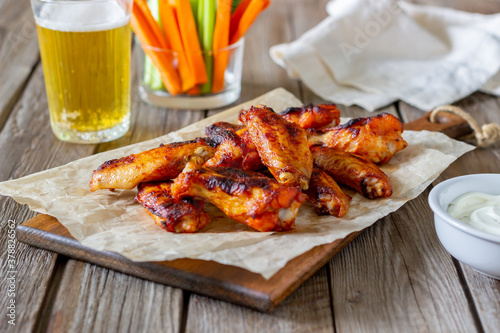 Barbecue chicken wings with carrots, celery and white sauce. Grill. Recipe.