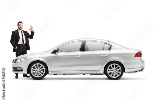 Businessman with a silver car and showing an ok sign