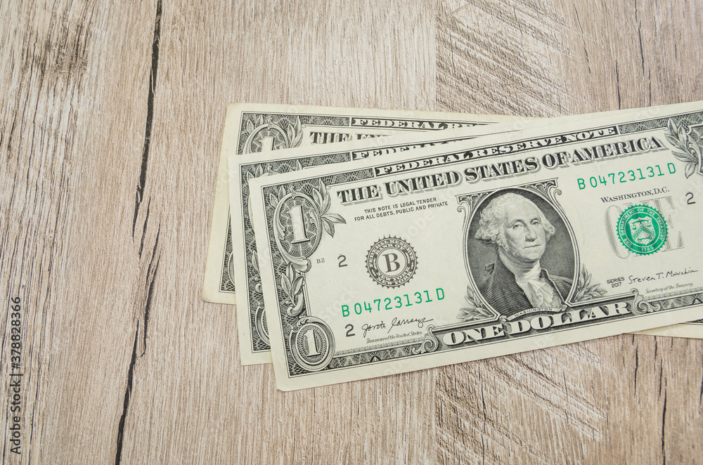 1 dollar bills on a wooden background. Financial concept. 1 dollar bills on a wooden background. Financial concept.