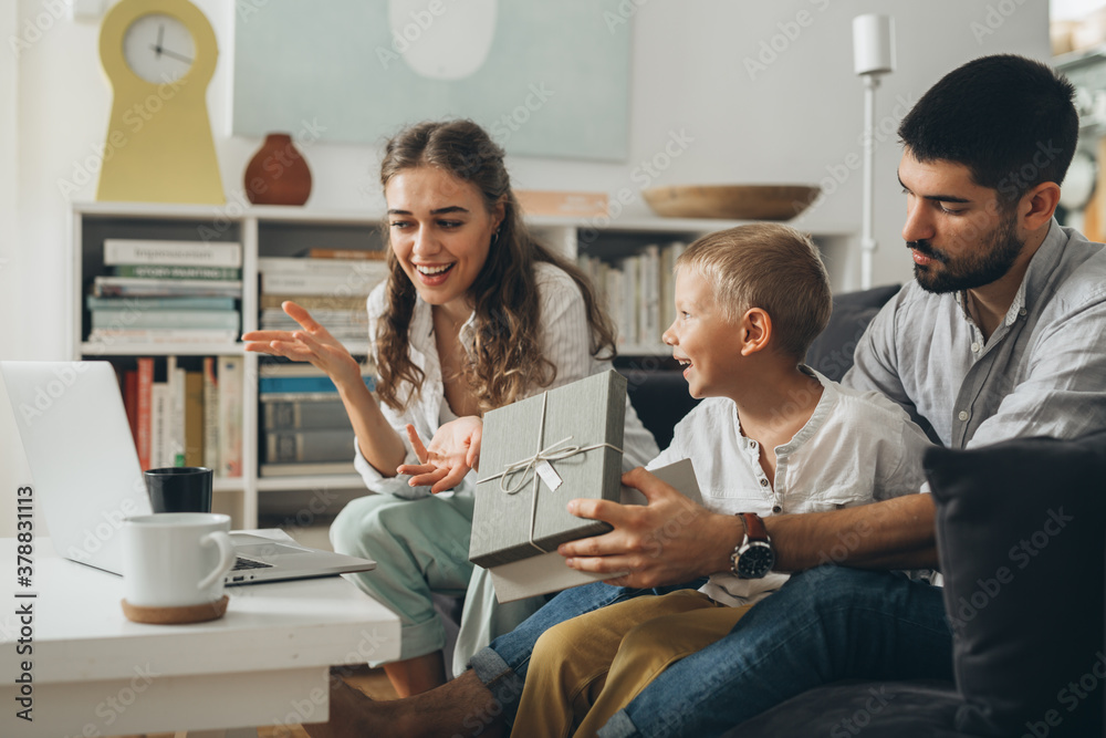 Obraz premium family open gift and having video call on laptop computer at home