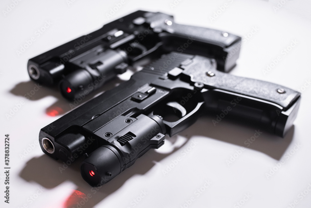 Pair of black toy guns with laser aim on a white background.