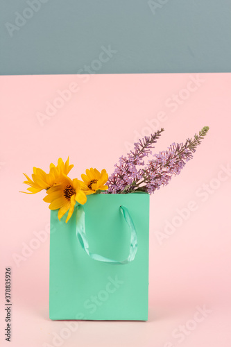 wild flowers, yellow and lilac in a gift bag, greeting concept, gift. space for text