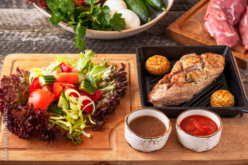 Roasted beef tenderloin on a pan served with fresh vegetables.