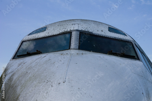 Vászonkép Nose of a grubby aeroplane with eyebrow windows, blue sky with copy space