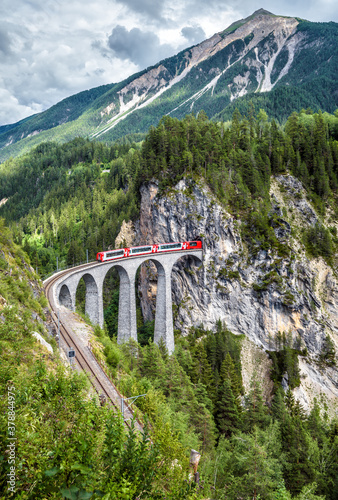 Landwasser Viaduct in summer, Filisur, Switzerland. Alpine landscape with Rhaetian express running on mountain railway. photo