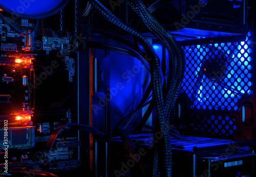 Computer illuminated by internal LED RGB lights, hardware inside open high performance desktop PC. Concept of gaming, repair, technology and wallpaper. photo