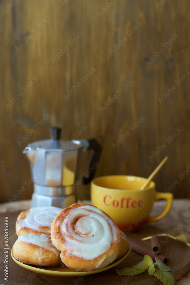 Geyser coffee maker and cinnamon bun on a wooden tray. With coffee cup and spoon. Dark background