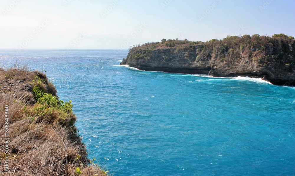 Scenic view of cliffs and blue ocean water in Nusa Penida, Indonesia