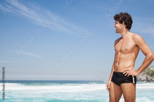 Hispanic man standing on tropical beach photo