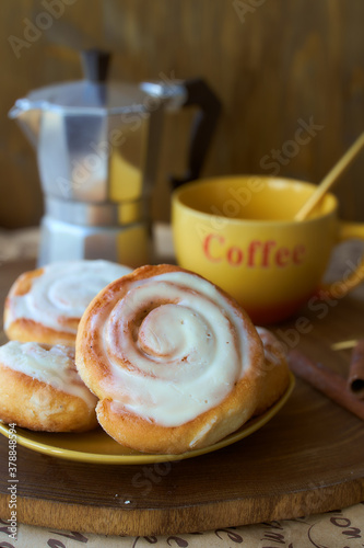 Geyser coffee maker and cinnamon bun on a wooden tray. With coffee cup and spoon. Dark background