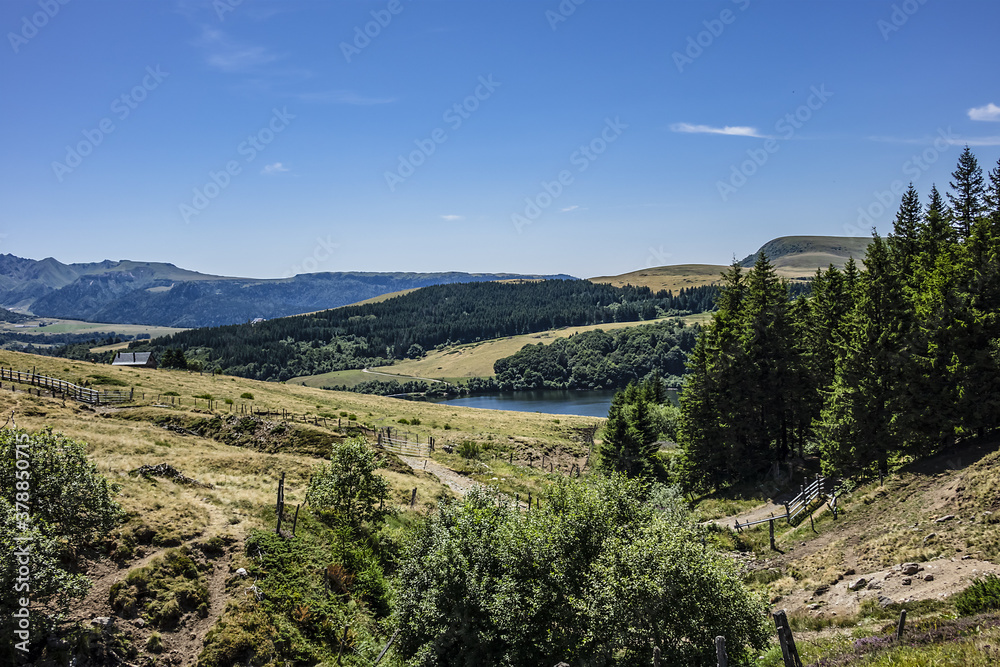 Fototapeta premium Highland landscapes in Volcans d'Auvergne regional Natural Park with Lac du Guery - highest lake in Auvergne at 1250m altitude. Massif Central, Auvergne-Rhone-Alpes administrative region, France.