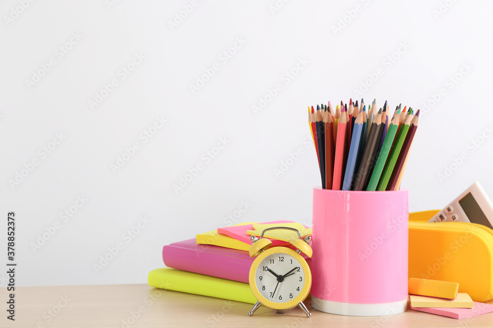 Fototapeta premium Different school stationery and alarm clock on table against white background, space for text. Back to school