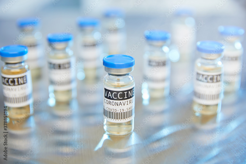 Group of Covid-19 coronavirus vaccine vials in laboratory on stainless steel table Group of Covid-19 coronavirus vaccine vials in laboratory on stainless steel table