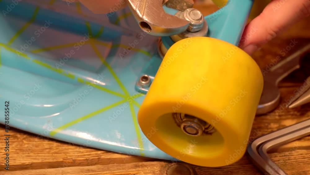 male hands repairing a broken skateboard. close-up.