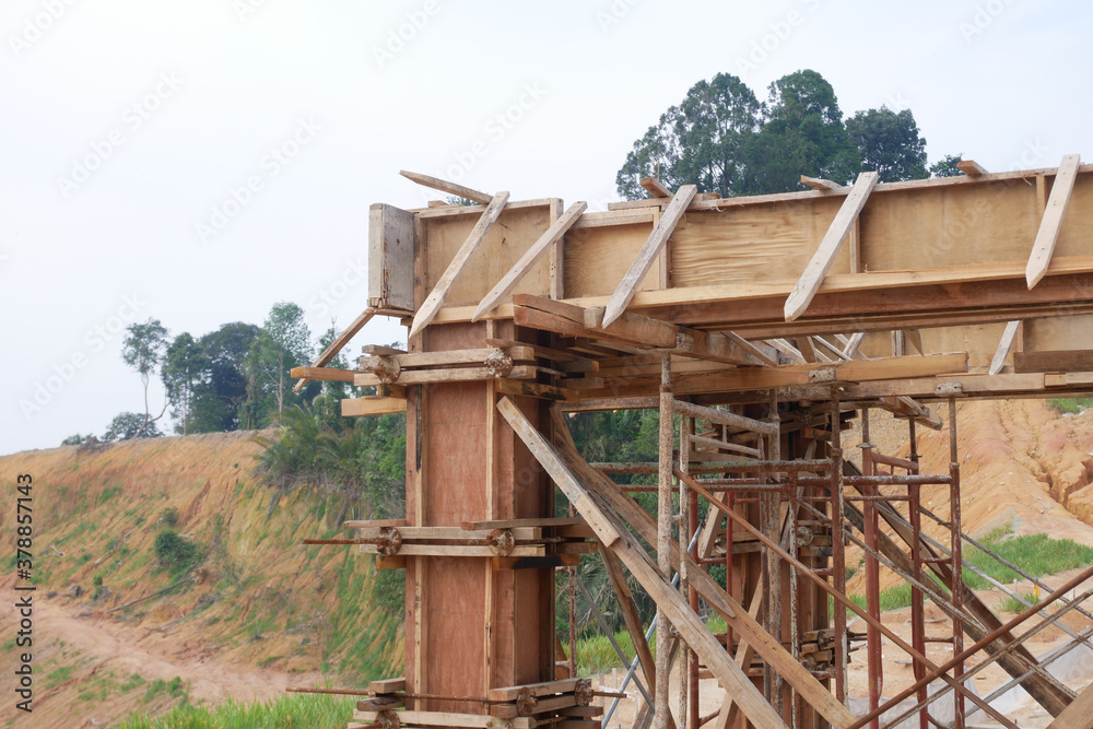 KUALA LUMPUR, MALAYSIA -SEPTEMBER 19, 2020: Column timber form work and reinforcement bar at the construction site. Installed by construction workers. The structure supported by temporary wood support